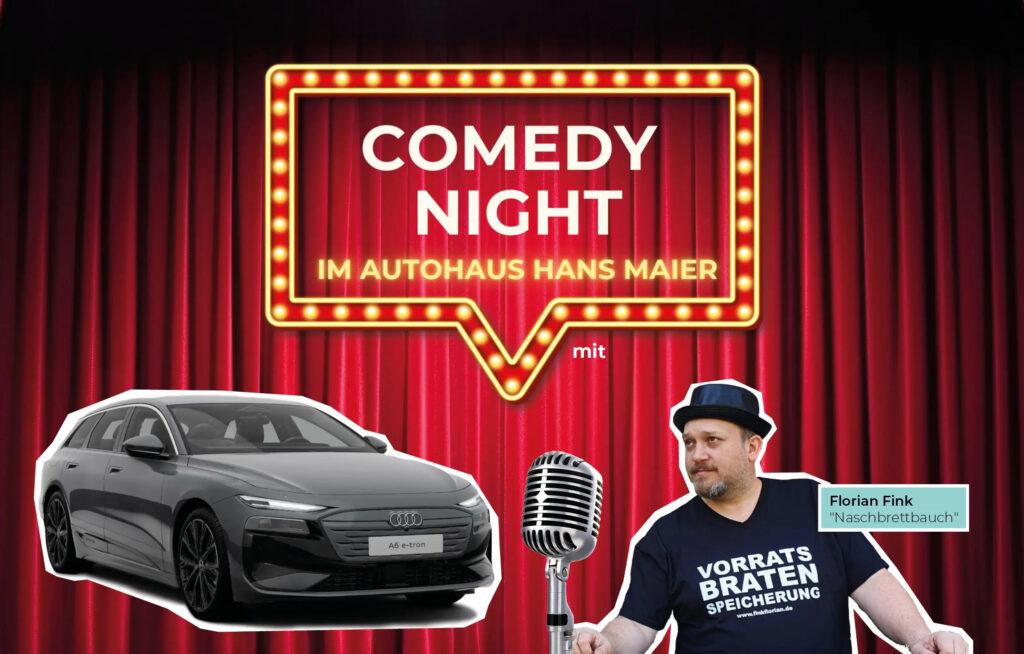 Audi A6 e-tron in grau und Florian Fink mit Werbeschild zur Comedy Night
