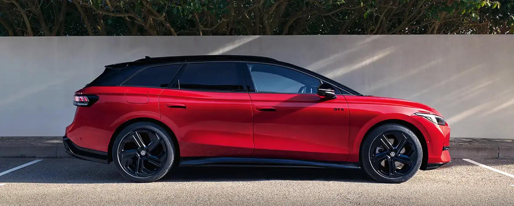 VW Leasing-Deals für Gewerbekunden 1 ID.7 Tourer GTX in rot mit Black Style Paket, seitlich fotografiert vor einer weißen Mauer