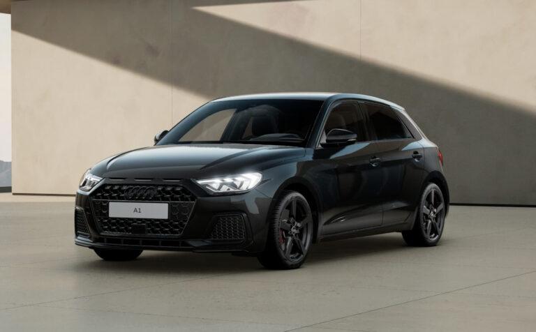 Audi A1 Sportback advanced 30 TFSI - Lagerwagen 4 Schwarzer Audi A1 Sportback mit sechseckigem Kühlergrill, LED-Scheinwerfern und sportlichen Felgen in einer hellen Halle.