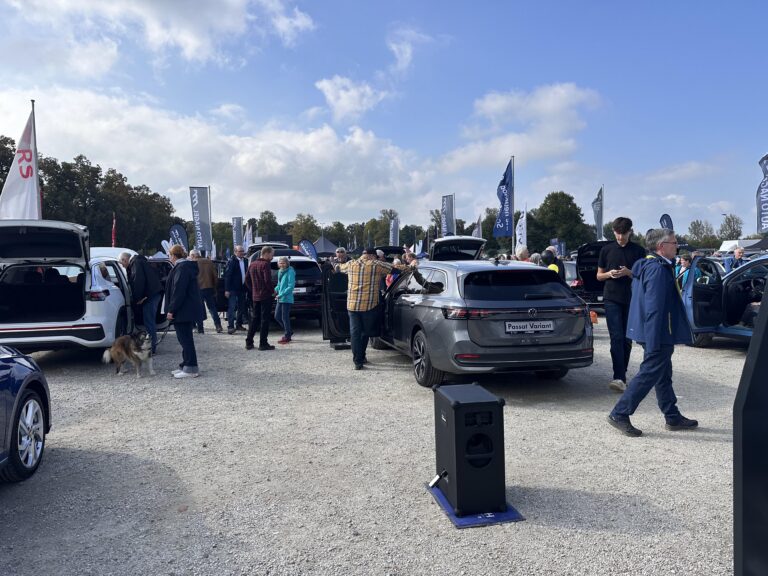Großes Interesse an der Automobil Ausstellung Erding 2025 14 Automobilausstellung Erding 2025 mit mehreren geöffneten Autos, Besuchern und Fahnen bei bewölktem Himmel.