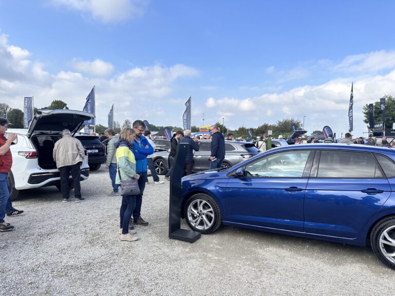 Großes Interesse an der Automobil Ausstellung Erding 2025 19 Mehrere Personen stehen zwischen geparkten Autos auf dem Platz der Automobilausstellung Erding 2025, darunter ein blauer Volkswagen Polo im Vordergrund.