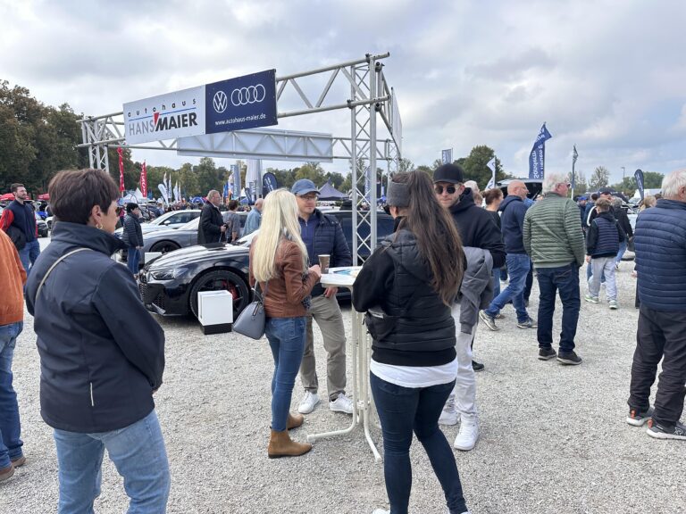 Großes Interesse an der Automobil Ausstellung Erding 2025 26 Menschen stehen auf dem Freigelände der Automobilausstellung Erding 2025 auf einem Audi-Stand mit Werbebannern von Autohaus Hans Maier.