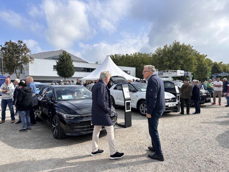 Großes Interesse an der Automobil Ausstellung Erding 2025 4 Außenbereich der Automobilausstellung Erding 2025 mit mehreren ausgestellten Autos und Besuchern, darunter ein schwarzes Fahrzeug im Vordergrund.