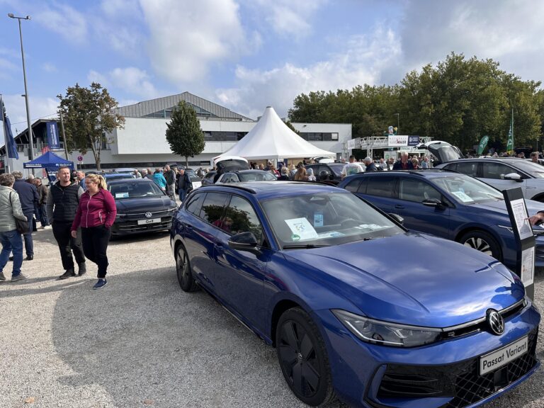 Großes Interesse an der Automobil Ausstellung Erding 2025 29 Blauer Volkswagen Passat Variant auf der Automobilausstellung Erding 2025, umgeben von Besuchern und weiteren Fahrzeugen, Zelt im Hintergrund.