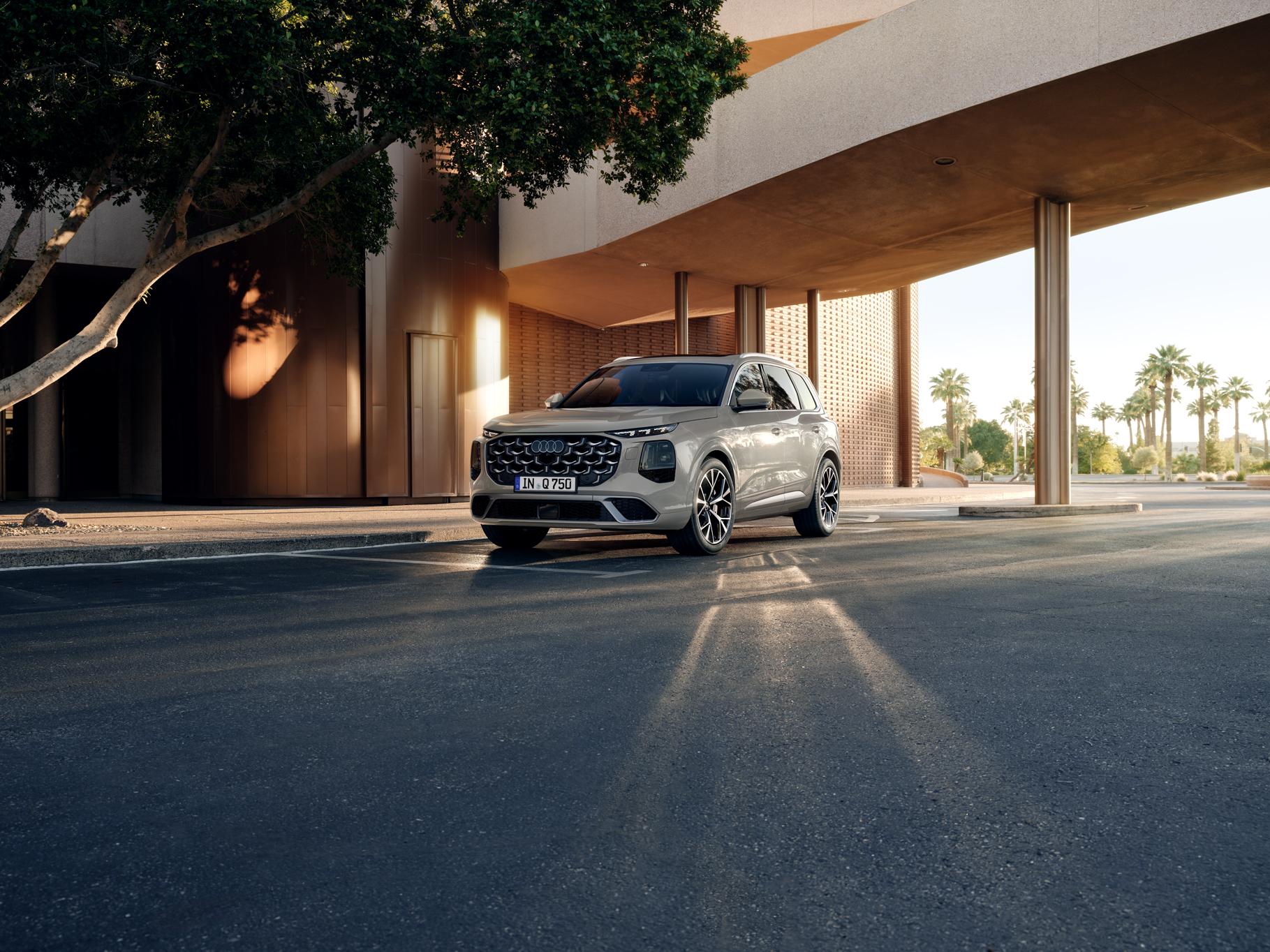 Beige Audi Q7 steht vor modernem Gebäude mit Säulen und Bäumen im Hintergrund