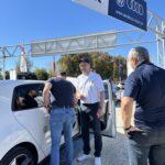 Drei Männer stehen an einem weißen Volkswagen im Autohaus Maier und führen ein Gespräch über das Fahrzeug.