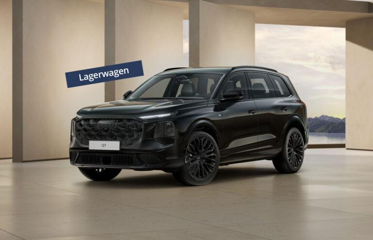 Schwarzer Audi Q7 SUV mit markantem Kühlergrill und großen Felgen in modernem Innenraum mit Säulen und Bergblick